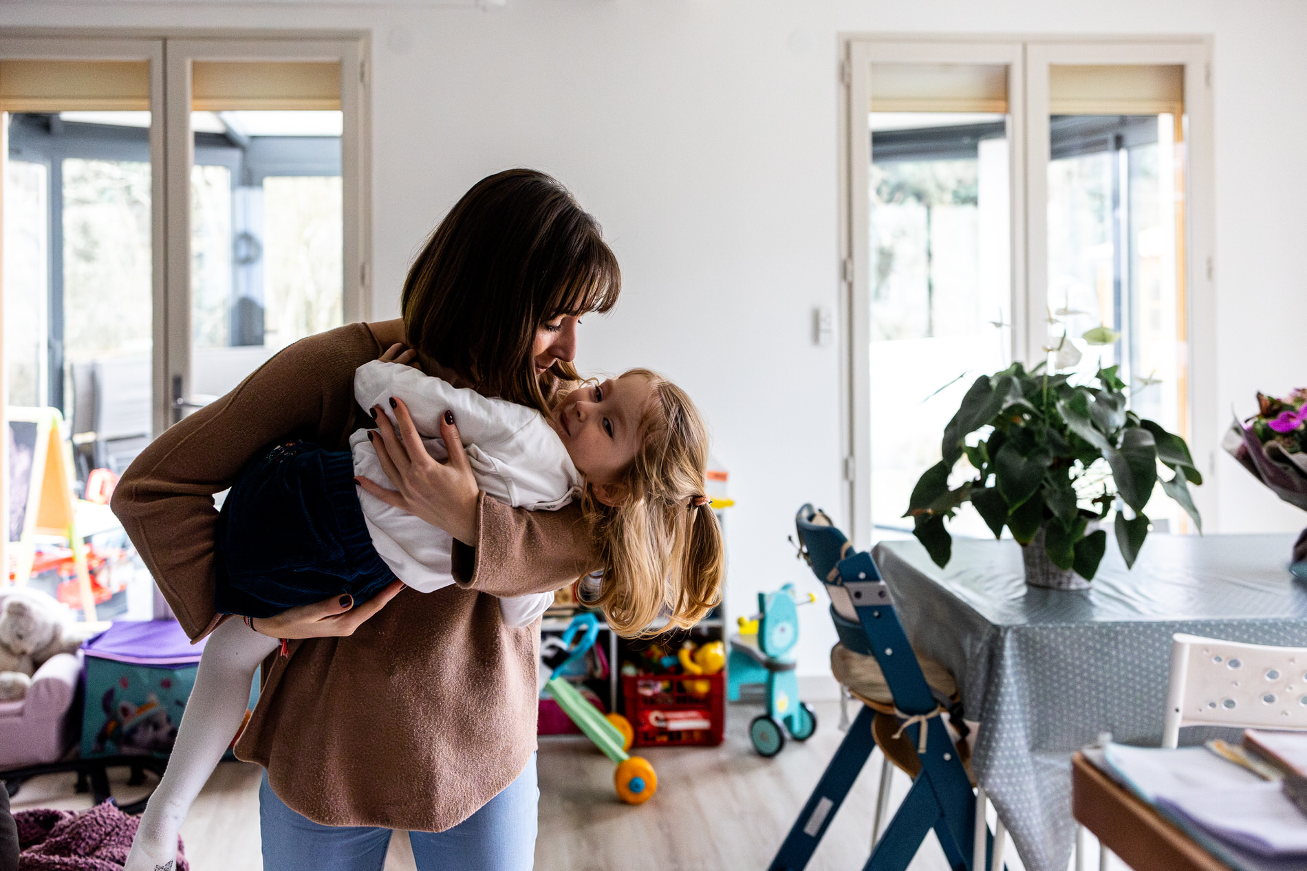 maman tenant sa fille cadette dans les bras pendant une seance photo famille avec camille piovesan