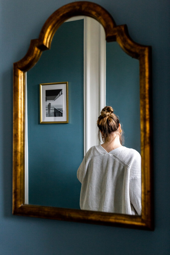 femme de dos dans le reflet d'un miroir dans une jolie maison ancienne