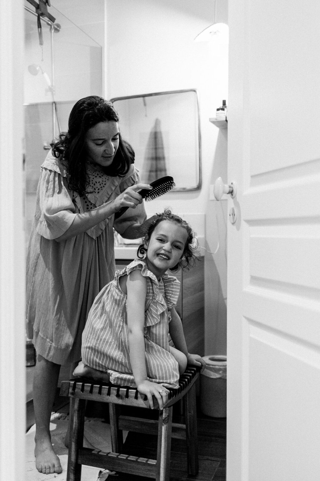 maman coiffant sa fille dans la salle de bain pendant un reportage photo famille avec camille piovesan