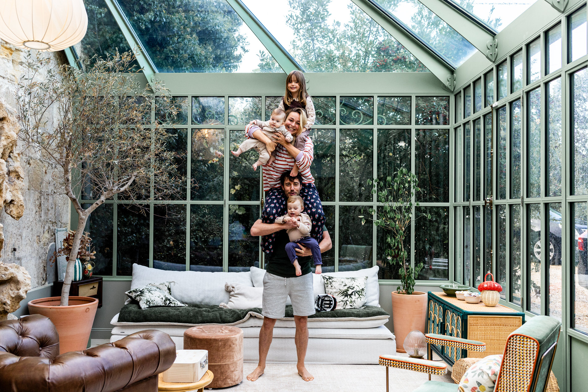 portrait d'une famille de 5 personnes en pyramide dans une verrière
