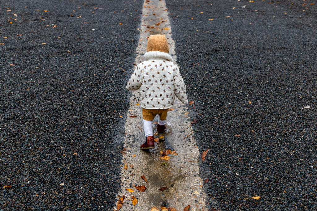 petite fille avec beguin marchant sous la pluie pendant un reportage photo famille
