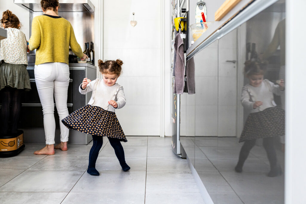 petite fille qui danse dans la cuisine prise en photo par camille piovesan photographe de famille