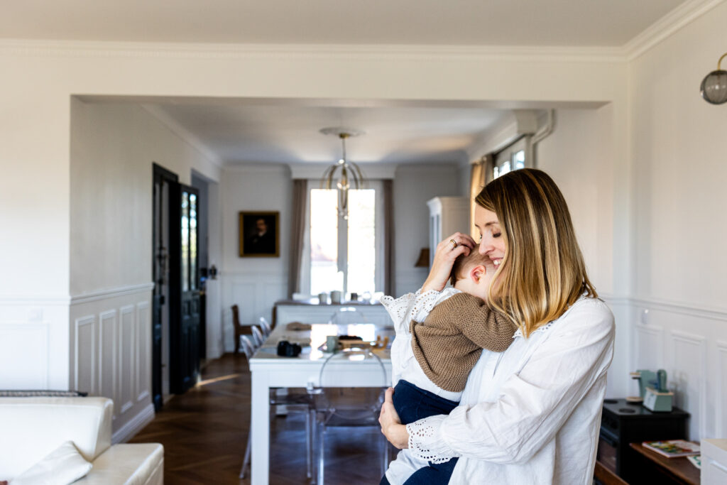 une maman tenant sa fille dans ses bras devant l objectif de camille piovesan photographe fontainebleau